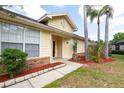 View of a charming one-story home featuring a well-maintained lawn with trees, and yellow siding at 321 Moffat Loop, Oviedo, FL 32765