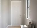 Bright foyer with a white front door, neutral walls, and a cushioned bench by the window at 1969 Portofino Meadows Blvd, Orlando, FL 32824
