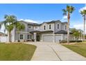 Well maintained two story home featuring a three car garage and palm trees, with a large front yard at 3209 Waterbridge Ct, Kissimmee, FL 34744