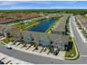 Wide aerial view of the townhome community with a lake, pool, green space, and surrounding trees at 4732 Coral Castle Dr, Kissimmee, FL 34746