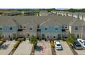 Aerial view of townhome showcasing landscaping, driveway, and other units in the community at 4732 Coral Castle Dr, Kissimmee, FL 34746