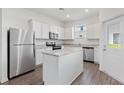 Modern kitchen with stainless steel appliances, white cabinetry, granite countertops and a center island at 824 Poppy Ln, Dundee, FL 33838