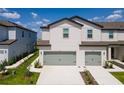 Charming townhome with two-car garage, landscaped walkway and light grey exterior at 854 Poppy Ln, Dundee, FL 33838