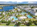 An aerial view showcasing the multiple community pools, palm trees and amenities near a lake at 8896 Reymont St, Orlando, FL 32827
