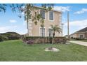 Charming home featuring beige stucco, a well-manicured lawn, and mature hedges at 112 Ivy Brook Ct, Davenport, FL 33897