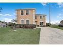 Charming two-story home featuring beige stucco, a well-manicured lawn, and a spacious driveway at 112 Ivy Brook Ct, Davenport, FL 33897