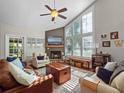 Bright living room featuring a vaulted ceiling, fireplace, and large windows with natural light at 128 Waverly Pl # 128, Orlando, FL 32806