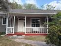 Inviting front porch with a swing and a view of the front yard at 13018 S Sunset Ter, Winter Garden, FL 34787