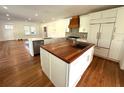 Modern kitchen with a wood-topped island, stainless steel appliances, and white cabinetry at 138 W Stetson Ave, Deland, FL 32720