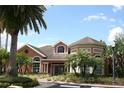 Stunning view of the building exterior featuring lush landscaping and brick paved walkway at 1969 Summer Club Dr # 209, Oviedo, FL 32765