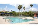 Beautiful community pool area featuring clear blue water, brick pavers, and palm tree landscaping at 1969 Summer Club Dr # 209, Oviedo, FL 32765
