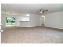 Bright, carpeted living room with open concept to the kitchen and rear patio access at 22 Laurel Crse, Ocala, FL 34480