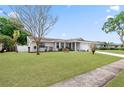 Well-maintained single-story home features a lush green lawn and mature trees, enhancing its curb appeal at 4729 Arrow Rd, Orlando, FL 32812