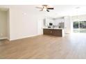 Open concept living space with modern flooring, a ceiling fan, and seamless flow into the kitchen area at 54 Malauka Trak, Ocklawaha, FL 32179