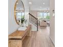 Bright entryway showcasing a stylish mirror, wooden bench, and staircase to the upper level at 5511 Flame Vine Way, St Cloud, FL 34771