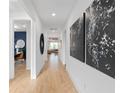 Bright hallway features wood flooring, contemporary art, and an open view into the living room at 5517 Flame Vine Way, St Cloud, FL 34771