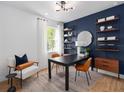 Stylish home office with modern furniture, a dark accent wall, and bright natural light at 5517 Flame Vine Way, St Cloud, FL 34771