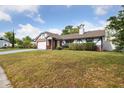 View of single Gathering home showcasing brick accents, a manicured lawn, and a two-car garage at 7602 Glenmoor Ln, Winter Park, FL 32792