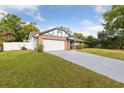 View of single Gathering home on a sunny day showcasing brick accents, manicured lawn and a two car garage at 7602 Glenmoor Ln, Winter Park, FL 32792
