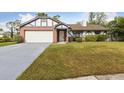 Charming single Gathering home showcasing brick accents, a well manicured lawn and a two car garage at 7602 Glenmoor Ln, Winter Park, FL 32792