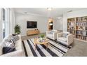 Bright, staged living room with sleek furniture, a modern rug, and an open concept design at 800 Marion Dr, Mount Dora, FL 32757