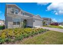 Attractive two-story home with a two-car garage, landscaped front yard, and modern architectural details at 13231 Panama Beach Ct, Orlando, FL 32827