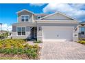 Charming two-story home with a two-car garage and well-manicured front yard featuring a brick driveway at 13231 Panama Beach Ct, Orlando, FL 32827