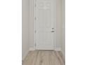Clean, bright entryway featuring modern wood-look flooring and a white door with chrome hardware at 1755 Waterview Dr, Leesburg, FL 34748