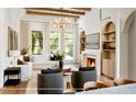 Bright living room with fireplace, custom built-ins, wood beam ceiling, and large windows at 1910 Glencoe Rd, Winter Park, FL 32789