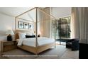 Relaxing bedroom featuring a four-poster bed, an accent chair, and a full glass exterior door at 1910 Glencoe Rd, Winter Park, FL 32789