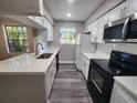 Bright kitchen with white cabinets, quartz countertops, black appliances, and wood-look flooring at 200 Afton Sq # 108, Altamonte Springs, FL 32714