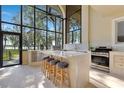 Modern kitchen featuring a large island, bar stool seating, and large windows with a lake view at 2910 Frontier Dr, Kissimmee, FL 34744
