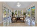 Elegant sitting room with marble floors, crystal chandelier, and large windows offering backyard views at 2910 Frontier Dr, Kissimmee, FL 34744