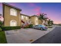 Condo building with well-kept landscaping, red stair accents, and ample parking under a beautiful twilight sky at 5201 Lake Marion Golf Resort # 5201, Kissimmee, FL 34759