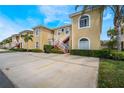 Charming condo building featuring two stories, yellow siding, white railings, and lush green landscaping with palm trees at 5201 Lake Marion Golf Resort # 5201, Kissimmee, FL 34759