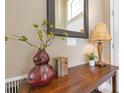 Close-up of the entryway's decor, including a decorative mirror, table lamp, books, and stylish decorations at 7018 Arcadian Ct, Mount Dora, FL 32757