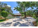 Charming red single-story home with spacious driveway and well-manicured lawn, combining curb appeal and functionality at 1010 N Clayton St, Mount Dora, FL 32757