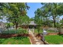 Charming red single-story home with a white picket fence, enhancing its curb appeal and inviting atmosphere at 1010 N Clayton St, Mount Dora, FL 32757