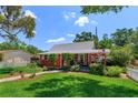 Charming two-story red home with a landscaped yard, quaint porch, and an American flag waving at 1010 N Clayton St, Mount Dora, FL 32757