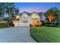 Elegant two-story home featuring a well-manicured lawn, three-car garage, and classic architectural details at 12706 S Lake Sawyer Ln, Windermere, FL 34786