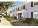 Charming condos with brick facade, dark shutters, manicured landscaping, and inviting entryway at 302 Lewfield Cir # 302, Winter Park, FL 32792