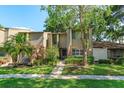 Attractive townhome featuring lush landscaping, brick accents, and a cozy front entrance at 487 Oak Haven Dr # 487, Altamonte Springs, FL 32701