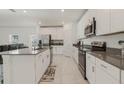 Bright kitchen with stainless steel appliances, white cabinets and gray countertops at 830 Turner Ln, Winter Haven, FL 33881