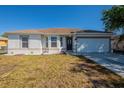 Beautiful single-story home showcasing a tidy lawn and a two-car garage at 104 Birmingham Dr, Kissimmee, FL 34758