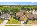 A sprawling single-Gathering home is showcased in this aerial shot with lush landscaping at 10820 Wyandotte Dr, Clermont, FL 34711