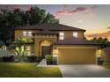 Inviting two-story home featuring a well-manicured lawn and an attached two-car garage at 10820 Wyandotte Dr, Clermont, FL 34711