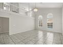 Bright living room with high ceilings, arched windows overlooking the pool, and stylish chandelier at 12557 Crayford Ave, Orlando, FL 32837