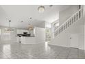Spacious living area with tile flooring, staircase, and open floor plan to the kitchen at 12557 Crayford Ave, Orlando, FL 32837