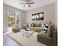 Open concept living room with a large couch, modern decor, and sliding doors to the backyard at 1312 Shinnecock Hills Dr, Davenport, FL 33896