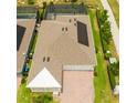 Aerial view of a home with solar panels, a paved driveway, manicured lawn, and white roof at 14711 Winter Stay Dr, Winter Garden, FL 34787